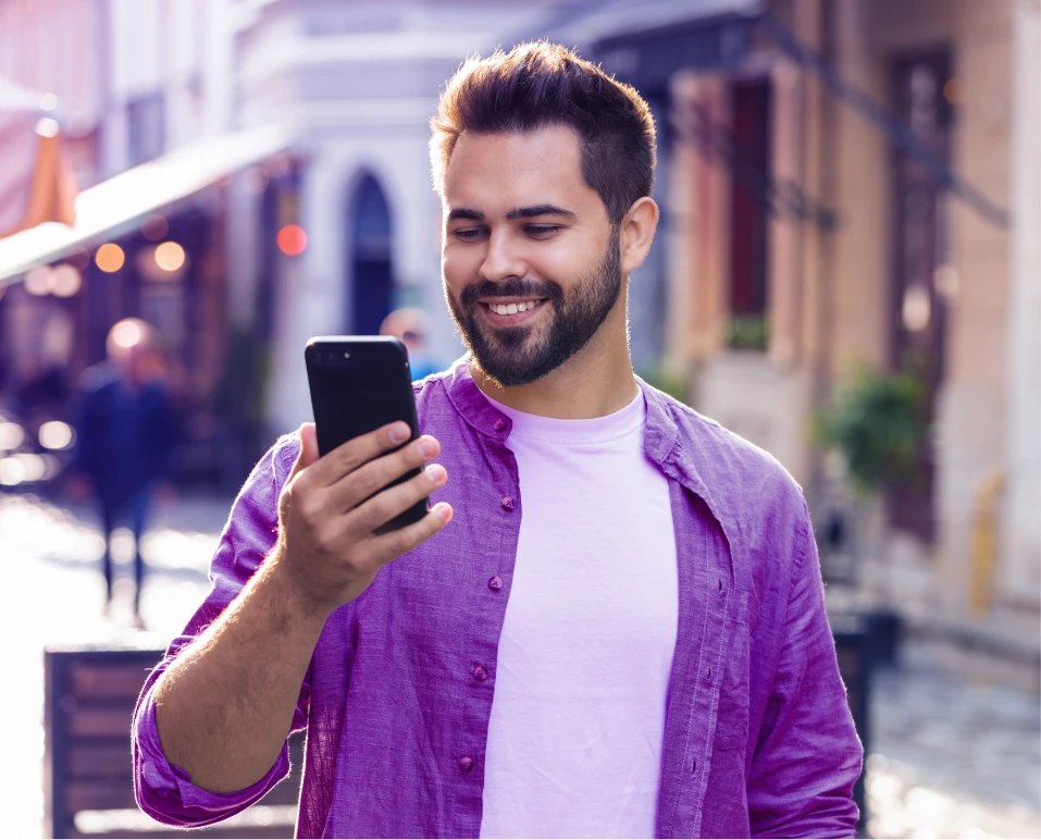 Homem sorridente usando o celular para antecipação do FGTS