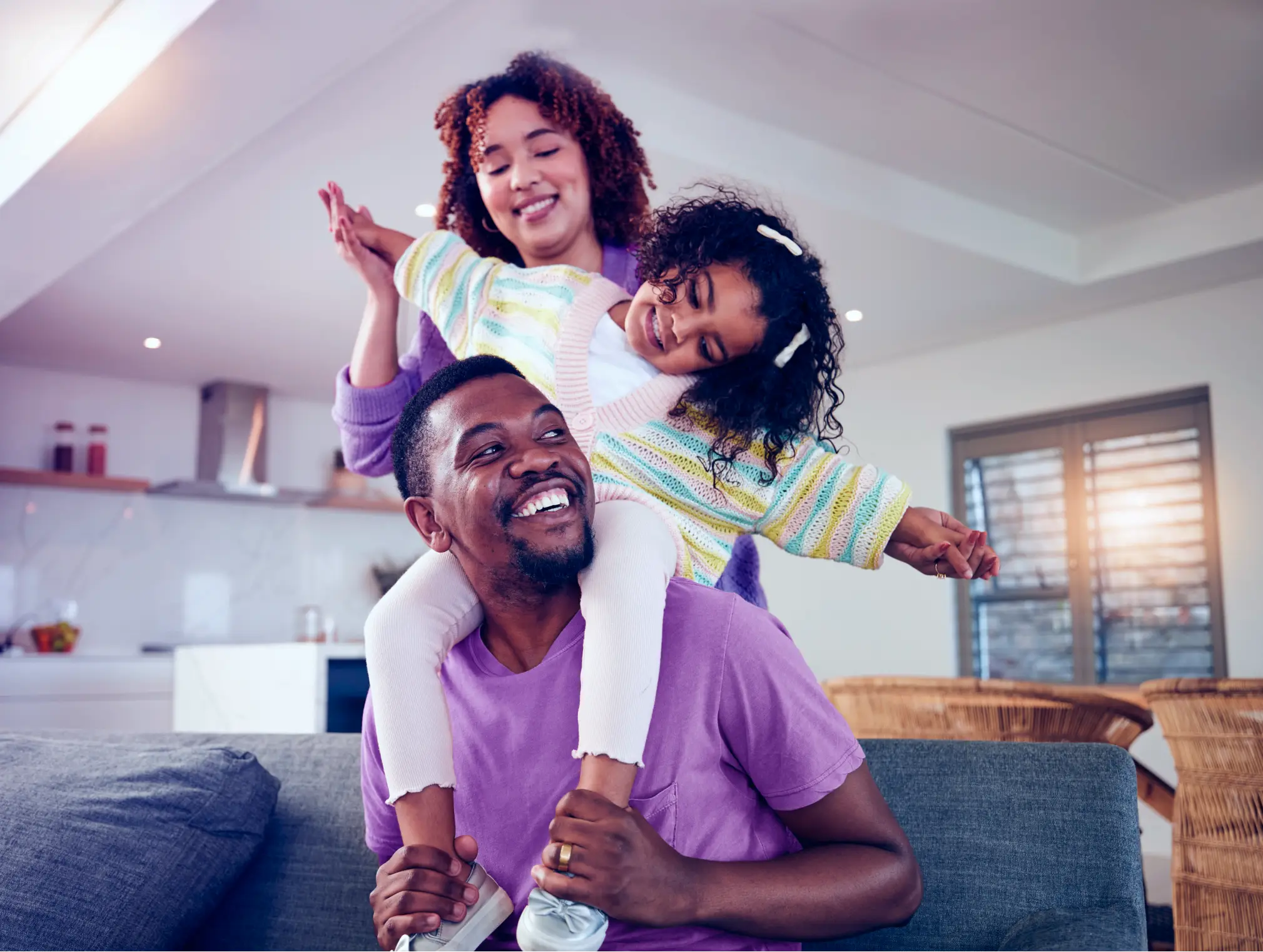 Família feliz no sofá representando tranquilidade financeira com a V8