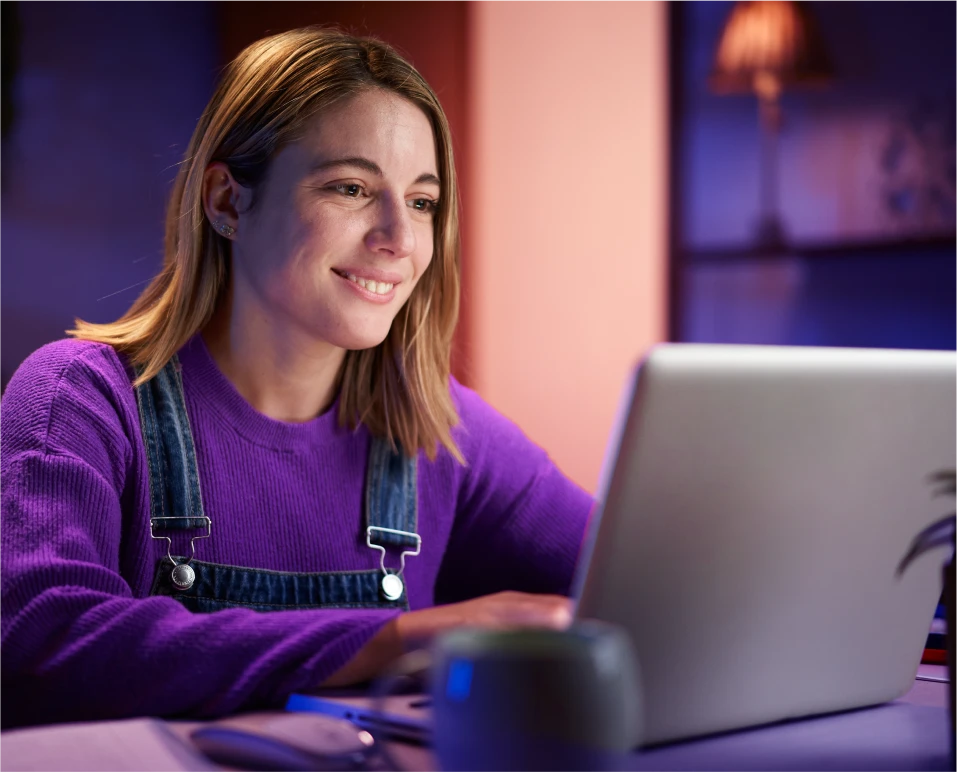 Trabalhadora CLT usando laptop para contratar crédito consignado com desconto em folha