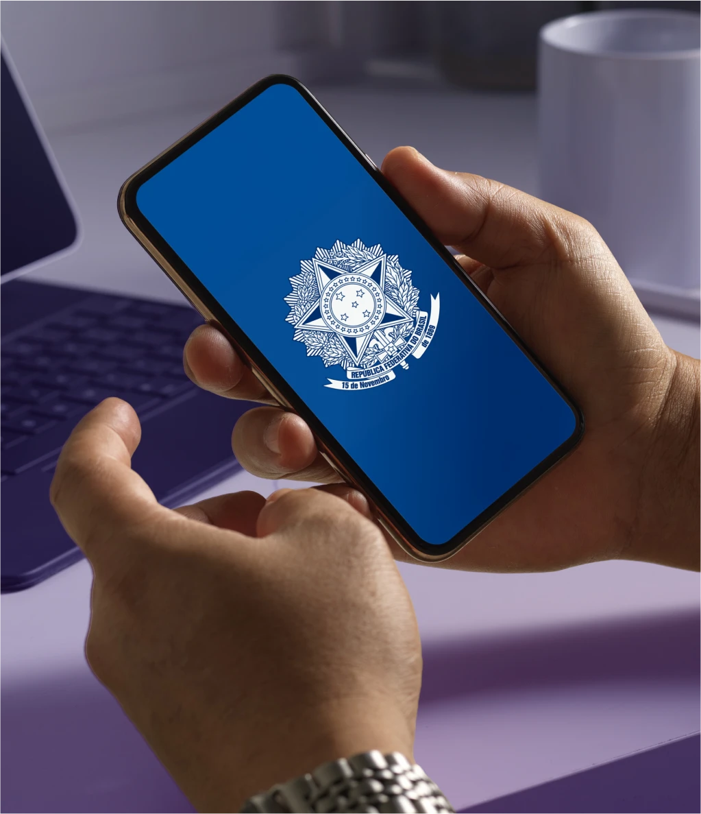 Pessoa segurando um celular com o símbolo do governo federal, representando benefício para trabalhadores CLT