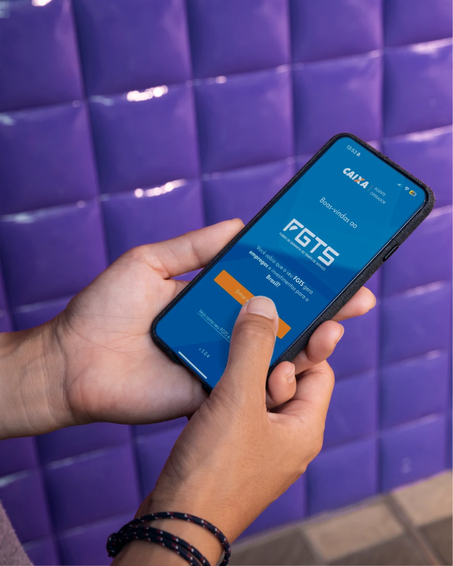Pessoa acessando o aplicativo do FGTS em um celular, representando saque digital